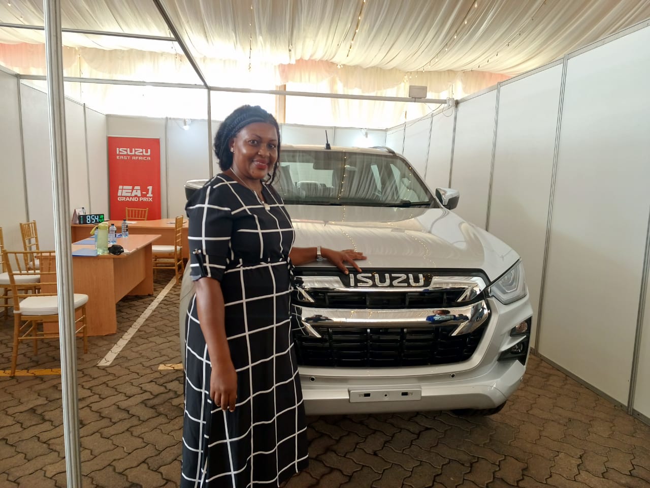Businesswoman with plaid blazer holding a magazine in a modern office. Bright and vibrant setting.